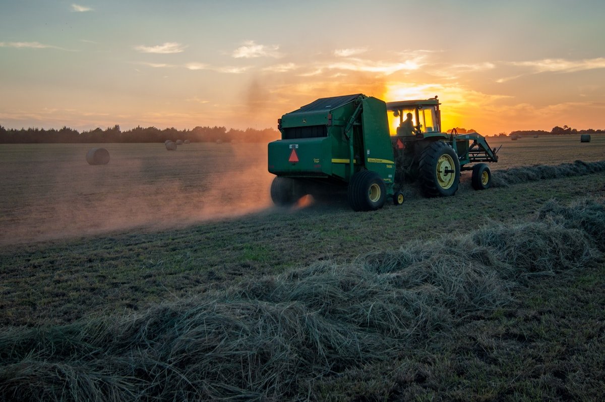 Máquina agrícola operando na lavoura ao entardecer